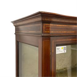 Edwardian inlaid mahogany serpentine display cabinet, projecting cornice over satinwood banding and stringing, enclosed by two glazed serpentine doors with panels to base, raised on square tapering supports with spade feet