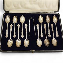 Set of twelve silver coffee spoons and tongs with shaped stems, London 1922 in Harrods case, silver preserve spoon and other silver cutlery 