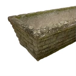 Three cast stone rusticated garden planters of tapering rectangular form 