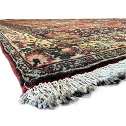 Kurdish rose ground runner rug, set with a series of ten floral medallions on linked field, the border decorated with stylised flower heads and bird motifs 