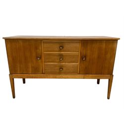 Gordon Russell - walnut sideboard, rectangular moulded top over three central drawers and flanking cupboards, fitted with turned handles, on tapering supports 