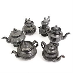 Six early 19th century and later black basalt tea and coffee pots, mostly with relief or engine-turned bodies, including a Cyples 'Egyptian black’ engine turned coffee pot on pedestal foot, another with shamrock, thistle and rose moulded decoration and four others 