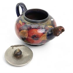 William Moorcroft Pomegranate pattern three piece tea service, comprising teapot with hammered pewter mounts and lid, sugar basin and hot water pot, all with pewter hammered finish mounts, possibly designed for Liberty & Co. 