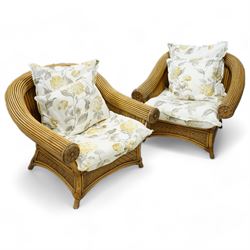 Pair of rattan cane work conservatory armchairs, with loose cushions upholstered in floral fabric