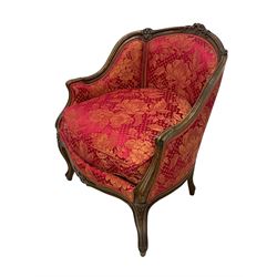 Late 20th century French design stained beech framed armchair and matching stool - the armchair with shaped and moulded frame carved with flower heads and foliage, upholstered in silk red and gold ground fabric with floral pattern, on scroll carved cabriole feet decorated with flower head carvings (W73cm, H82cm, D75cm); the footstool of concaved rectangular form with moulded frame carved with flower heads, upholstered loose cushion, on cabriole feet (70cm x 64cm, H48cm)