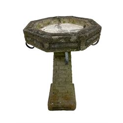 Circular cast stone garden planter decorated with flower head band (D44cm, H28cm); smaller planter (D34cm, H27cm); composite stone rusticated bird bath, octagonal top on tapering pedestal (W41cm, H65cm) (3)