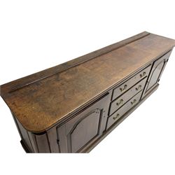 George III oak dresser base, rectangular top with rounded corners over moulded frieze rail, canted corners with turned quarter columns, fitted with three drawers with moulded edges flanked by two cupboards, enclosed by ogee arched fielded panelled doors, panelled sides, moulded plinth base